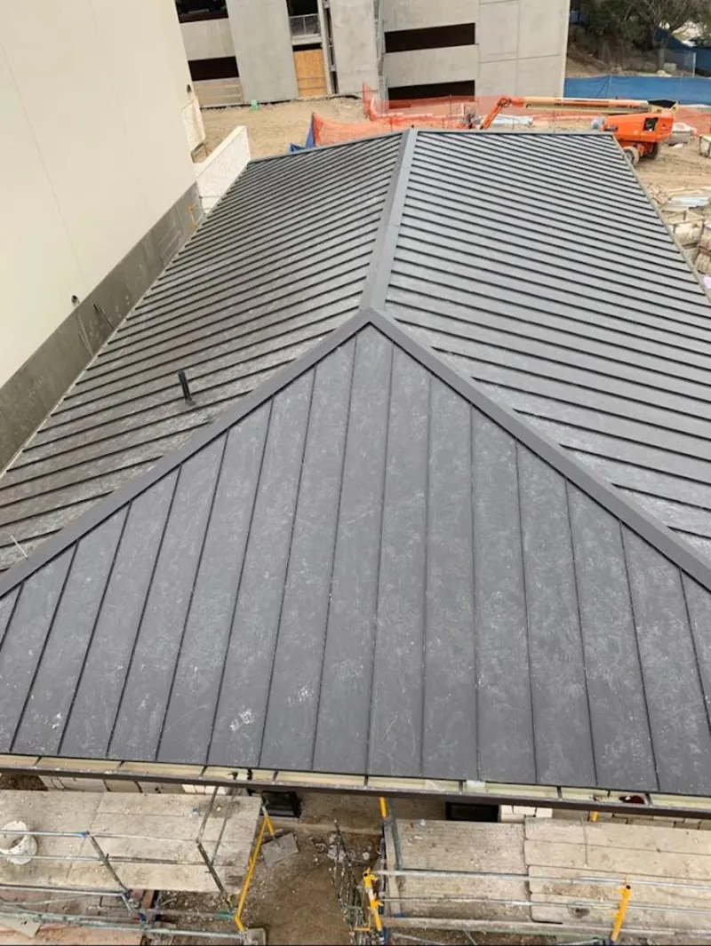 Commercial metal roof construction with crane equipment in South Amboy